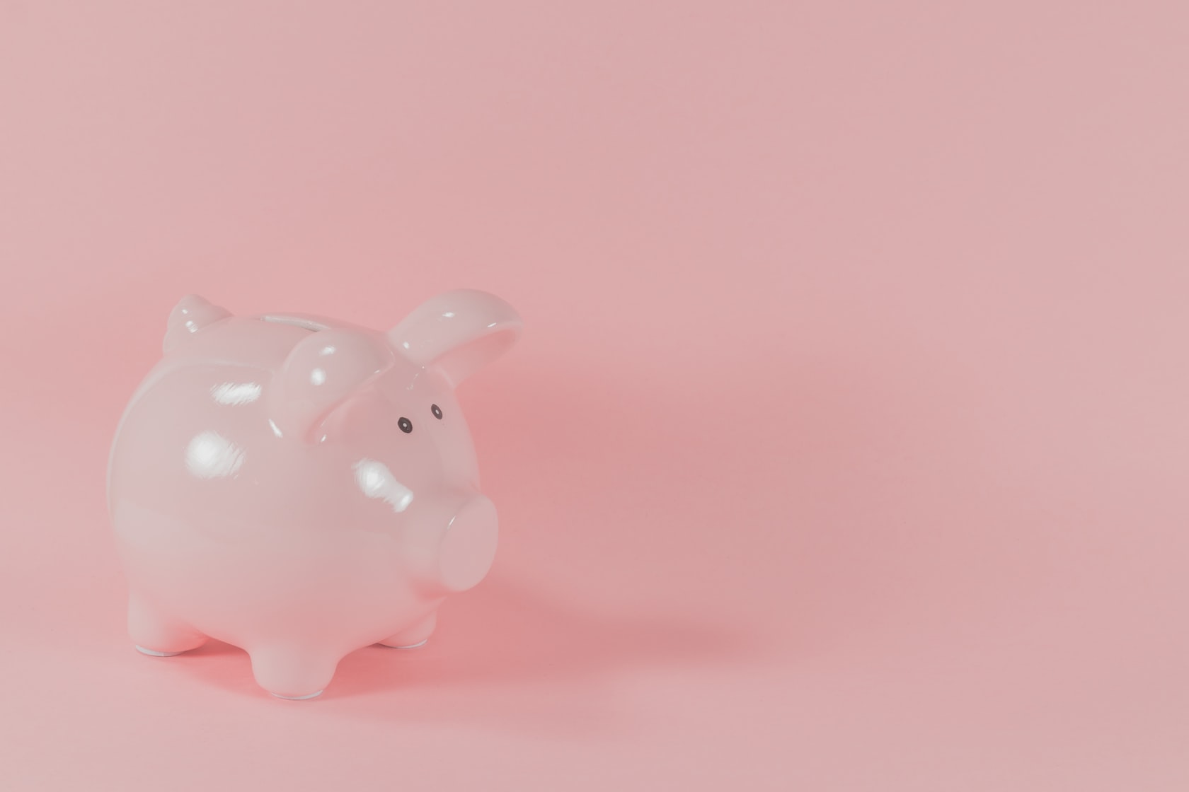 The image shows a pink piggy bank, symbolizing cost savings from using a water softener to reduce appliance maintenance, energy consumption, and detergent expenses