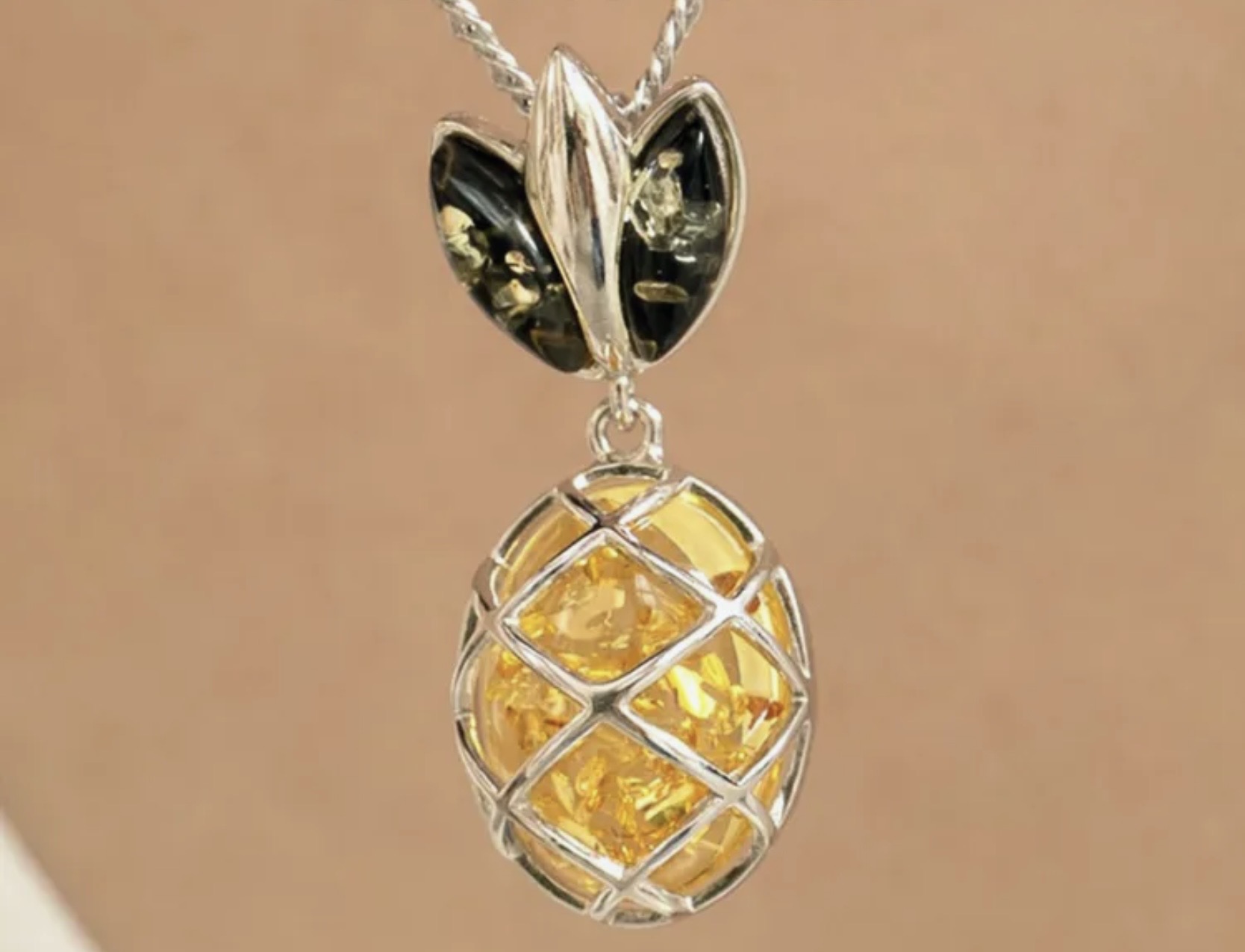 Pineapple amber pendant in a sterling silver cage