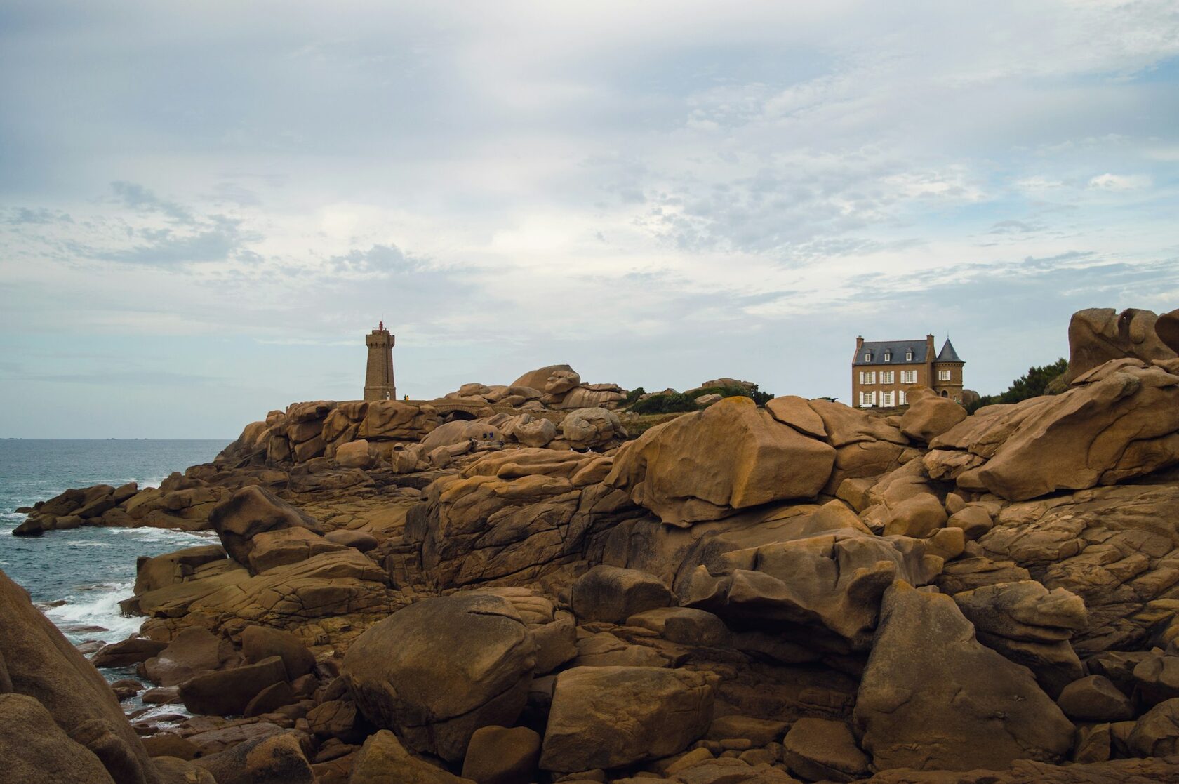 The pink granite rocks and lighthouse of Ploumanac'h on the Brittany coast at golden hour