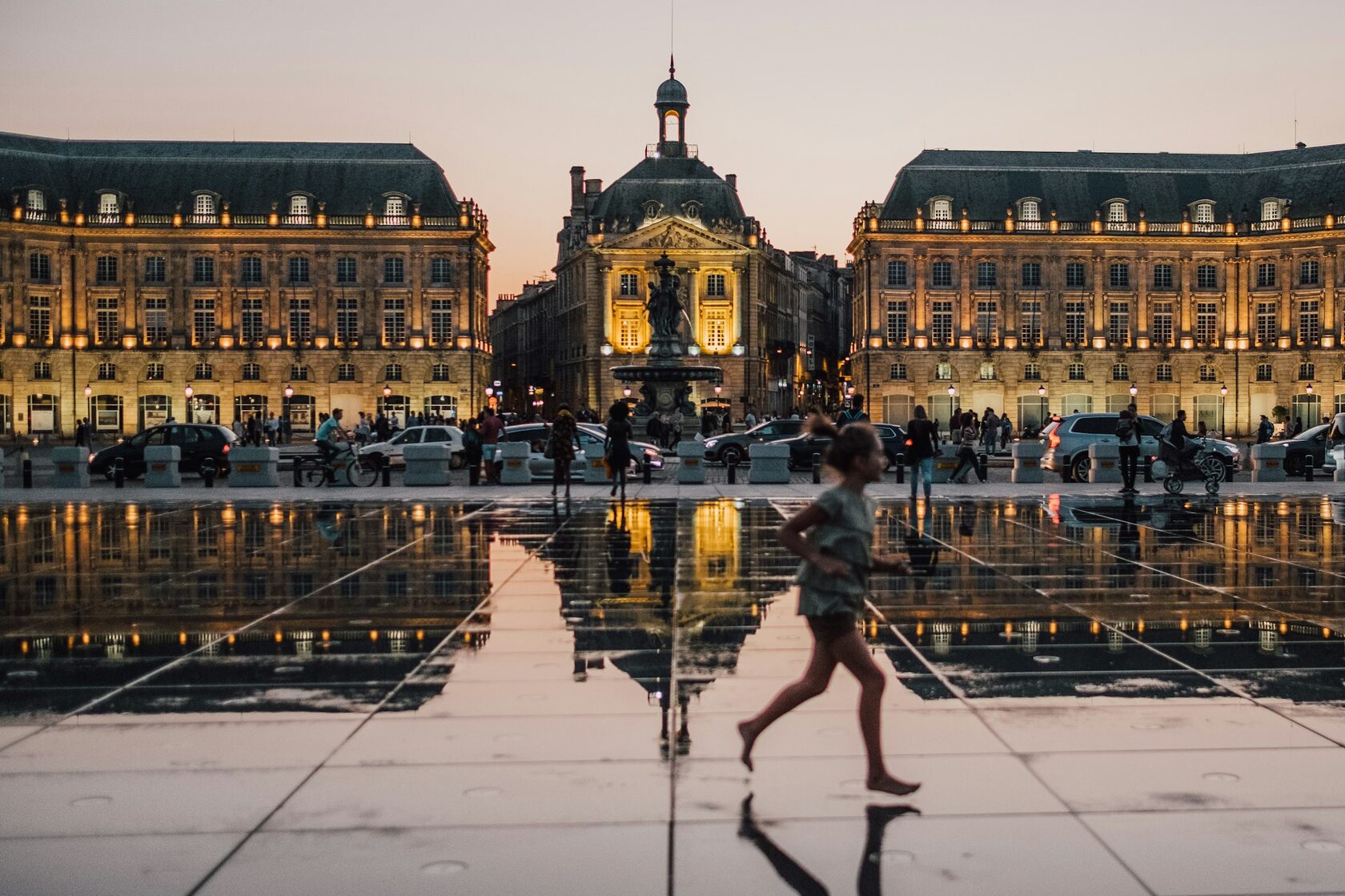 Bordeaux's Water Mirror reflecting the illuminated Place de la Bourse at dusk