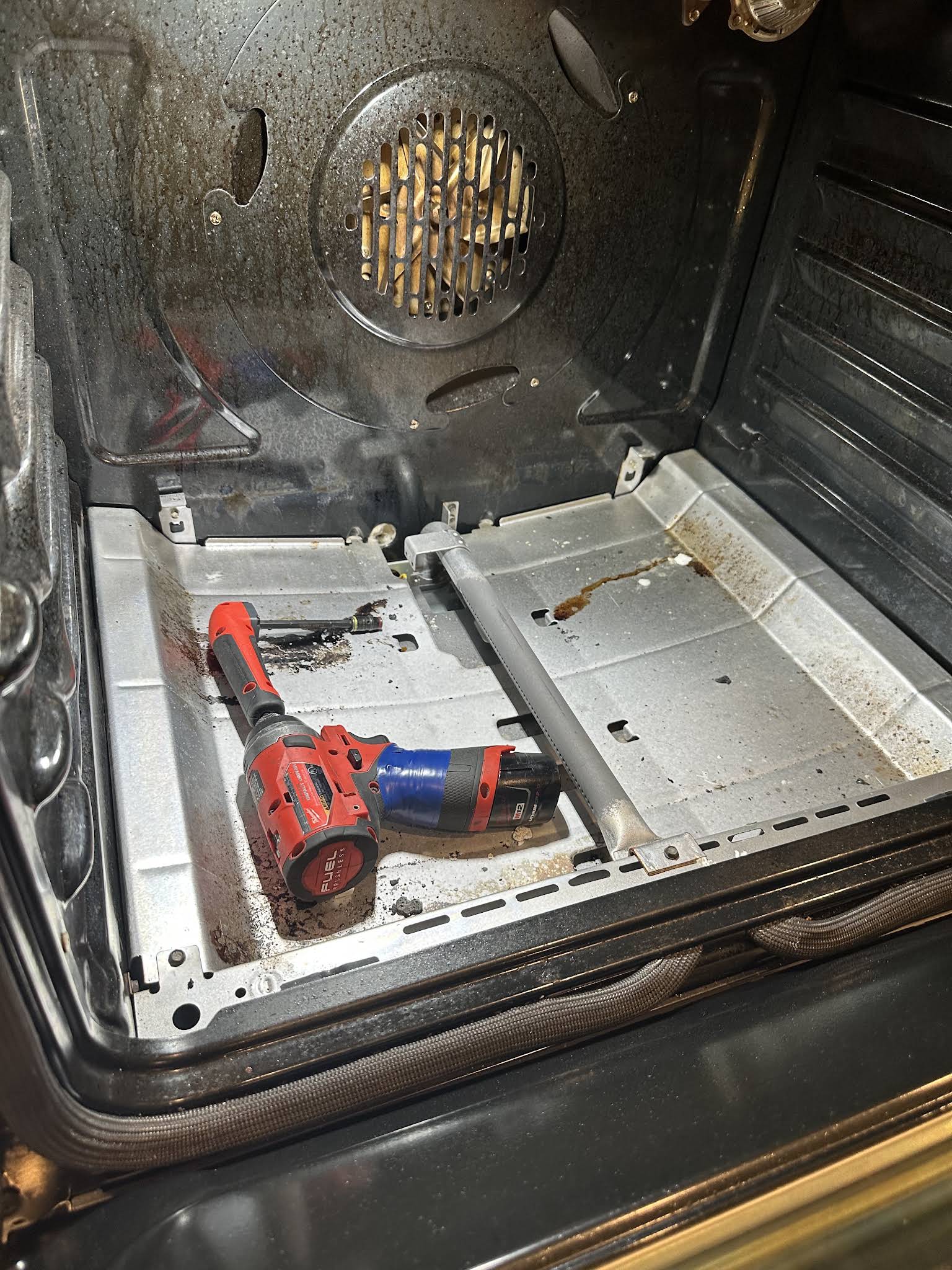 Oven interior with the bottom panel removed during an oven repair in Dade City, FL by AVM Services