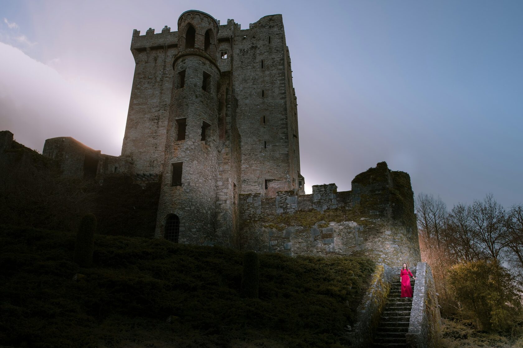 A couple sharing a quiet moment together among the weathered ruins of an old Irish castle, warm golden light on the stone.