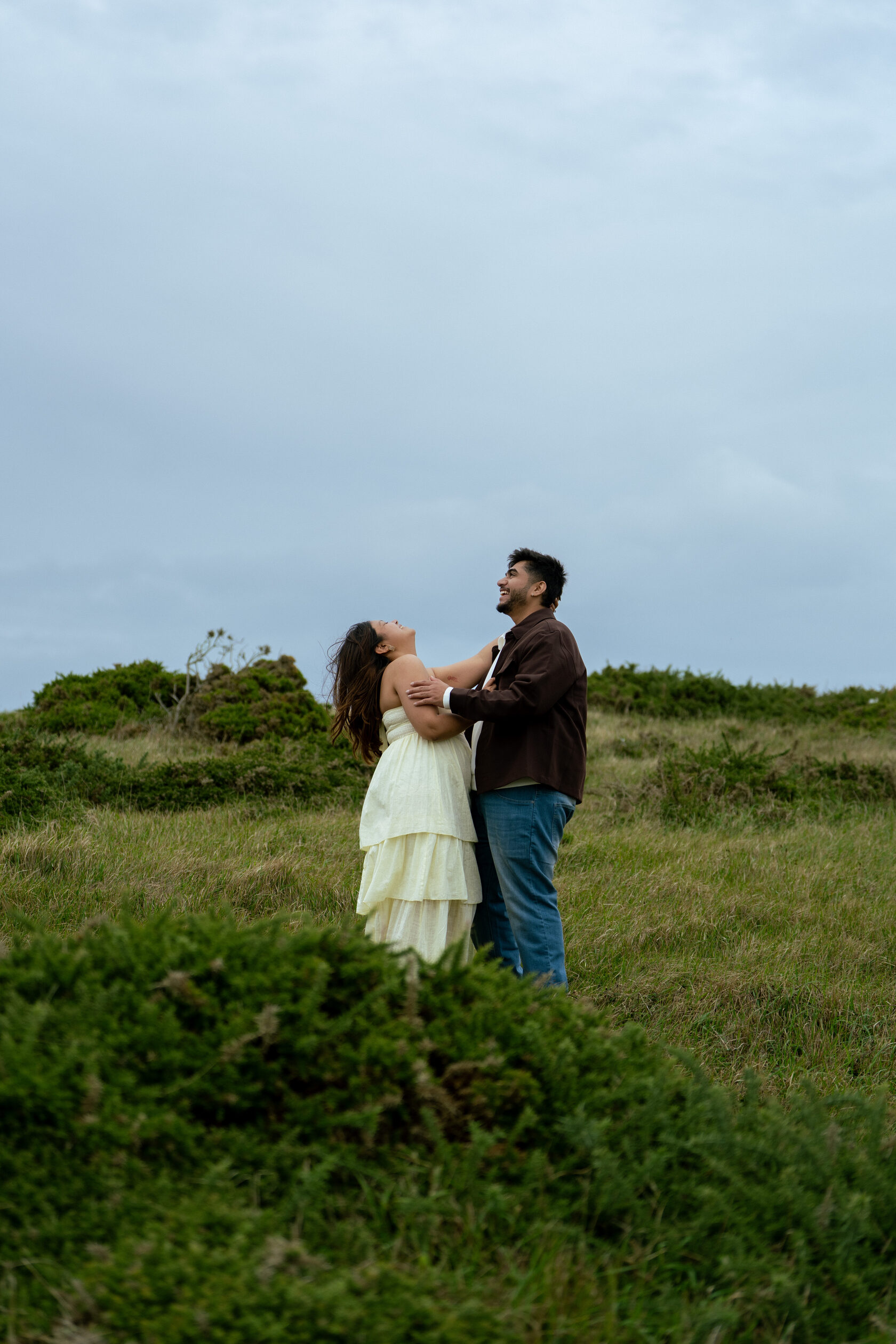 Couple smiling together among coastal greenery
