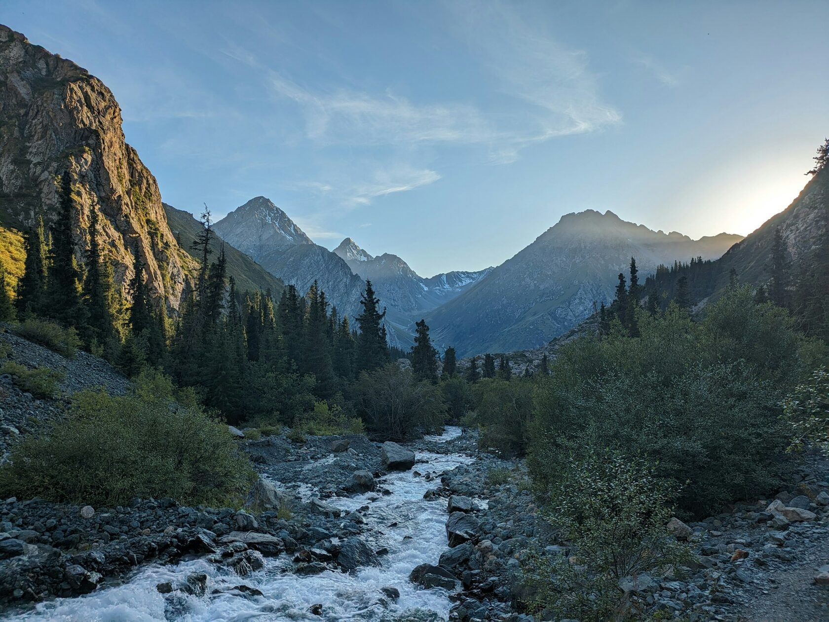 Hikers on the forest trail of Karakol Gorge leading to a mountain yurt camp