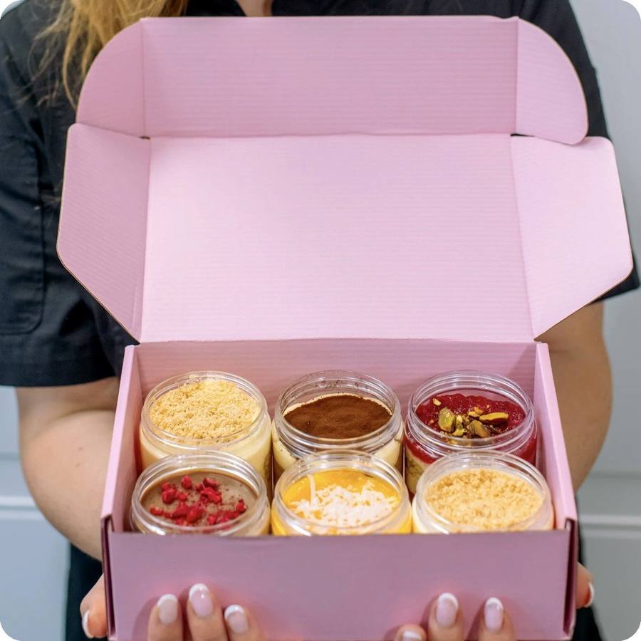 Olesya holding a box of six dessert jars