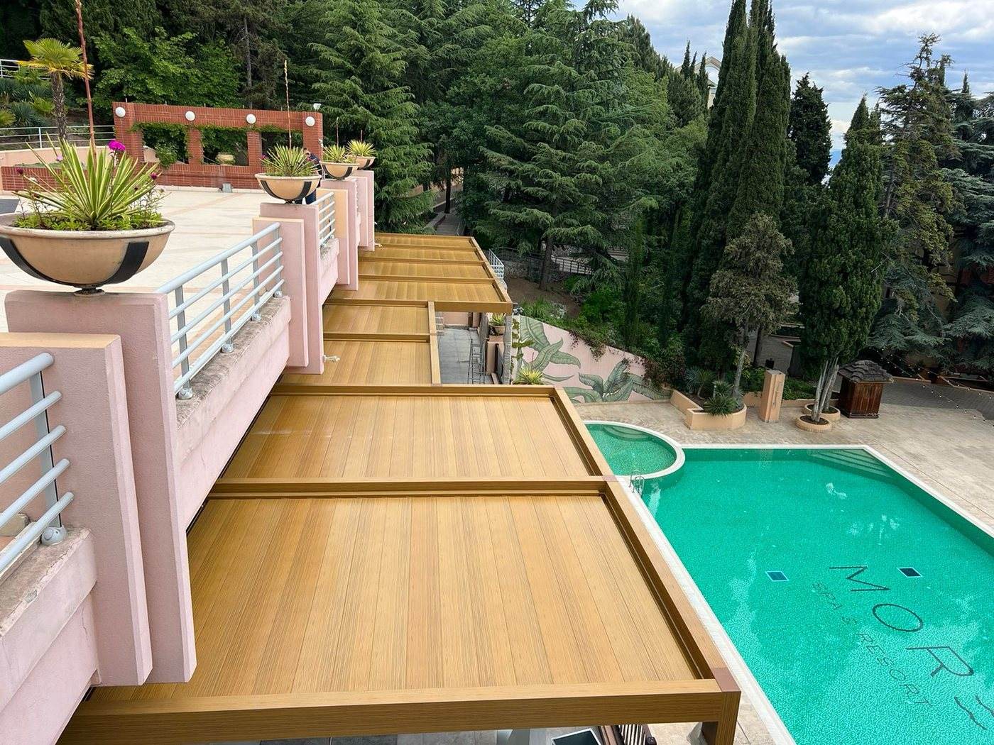 Timber louvered roof over a terrace above a pool