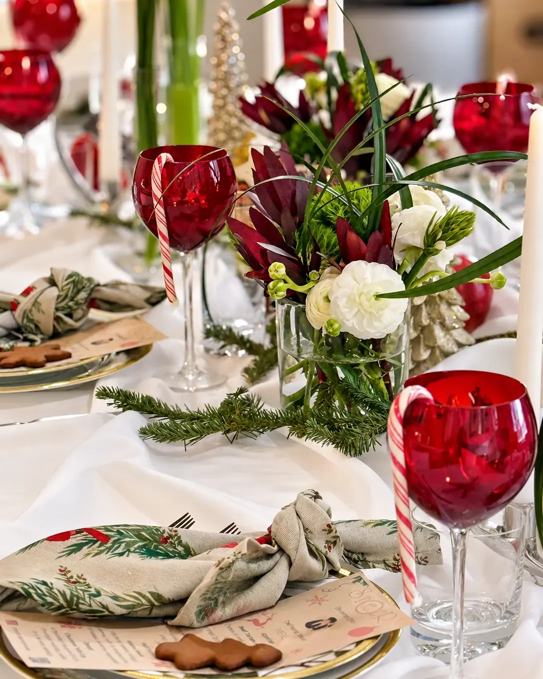 Red glasses with candy canes and ranunculus — a Christmas dinner at home by Miami private chef Marina Staver