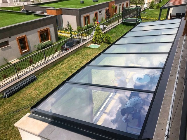 PRADA Q42 glass roof over a house terrace with a green roof