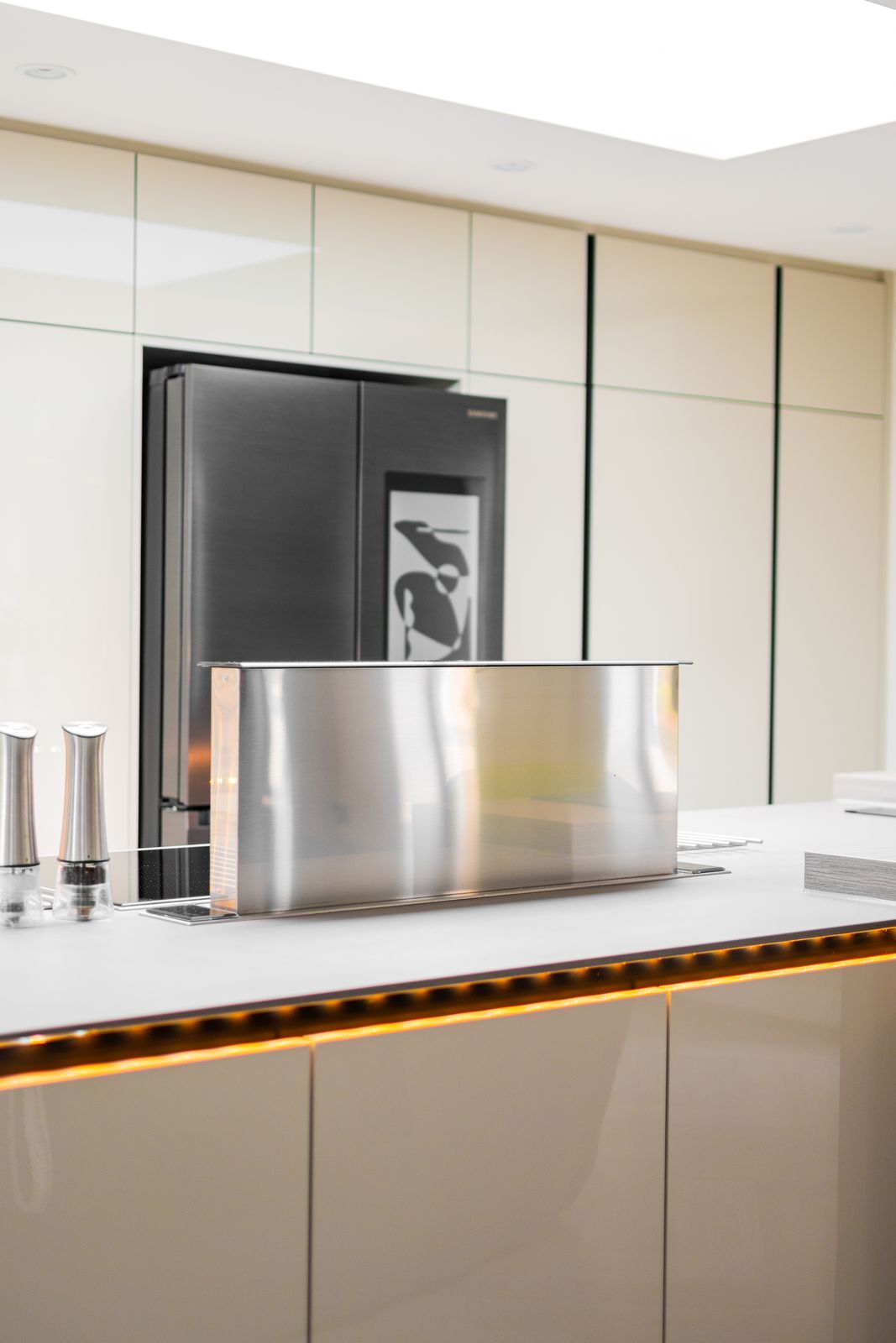 Kitchen island with induction hob and pop-up downdraft extractor, underlit worktop edge