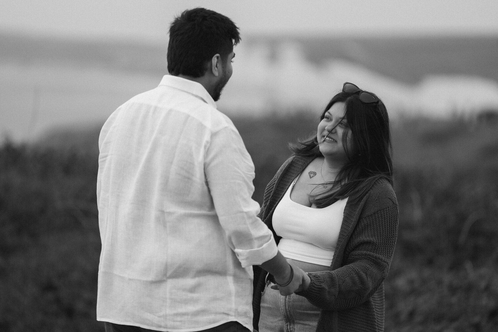 Black-and-white photograph of a couple smiling during their proposal
