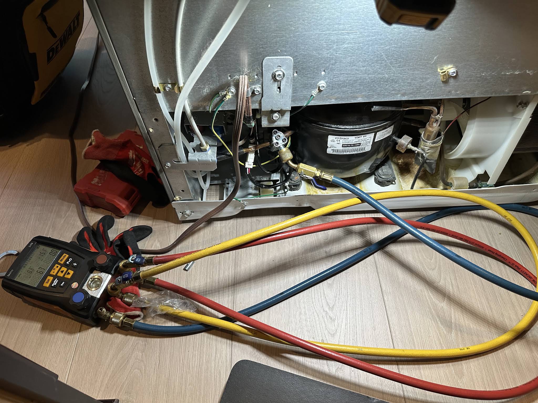 Refrigerator compressor and refrigerant gauges during an appliance repair in Lutz, FL by AVM Services