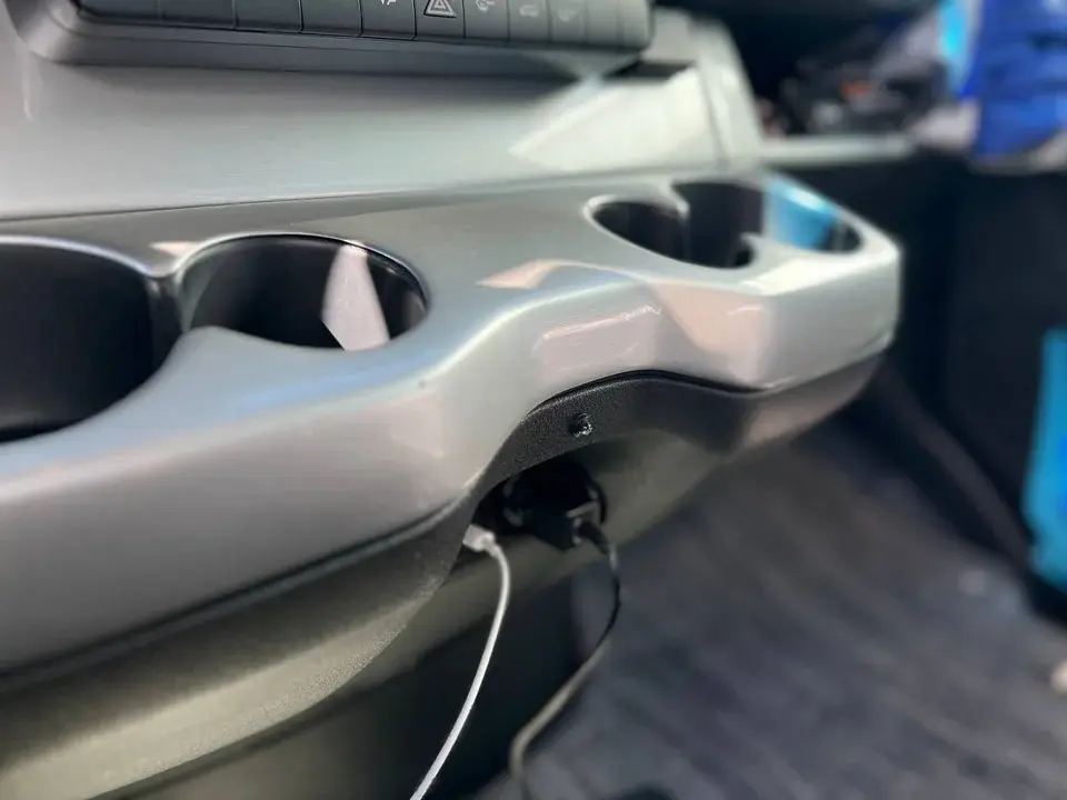Sprinter dashboard and cup holders with a small round component visible beneath the trim.