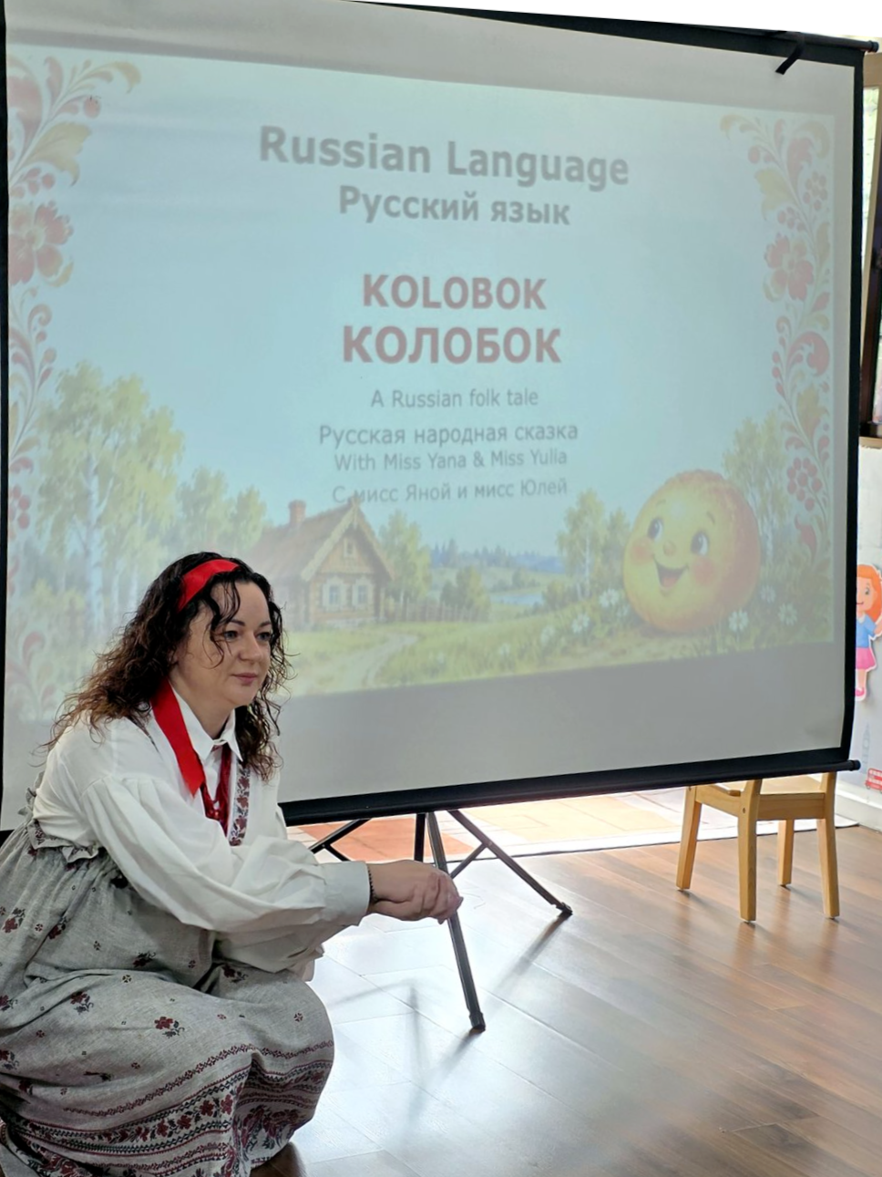 Учитель у экрана с заставкой сказки «Колобок»