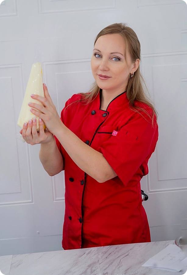 Olesya, founder of Art Cakes Studio, in a red chef coat