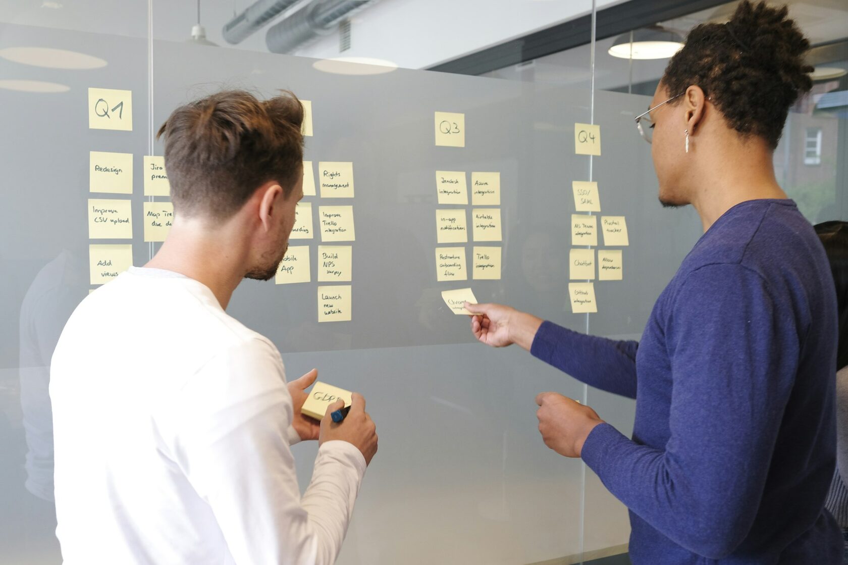 Equipe reunida em uma oficina colaborativa, com post-its coloridos na parede.