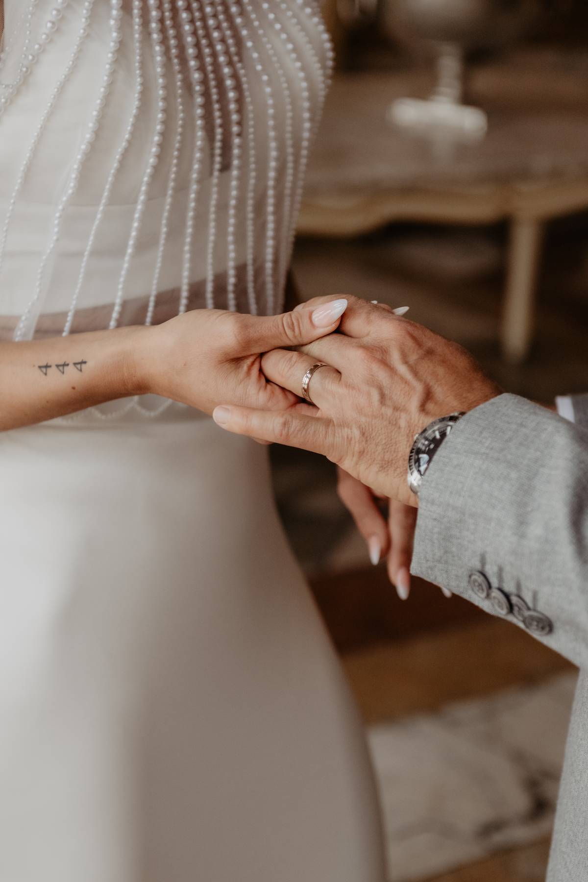 Close-up of bride and groom holding hands, showing their wedding rings during their intimate Salzburg wedding.