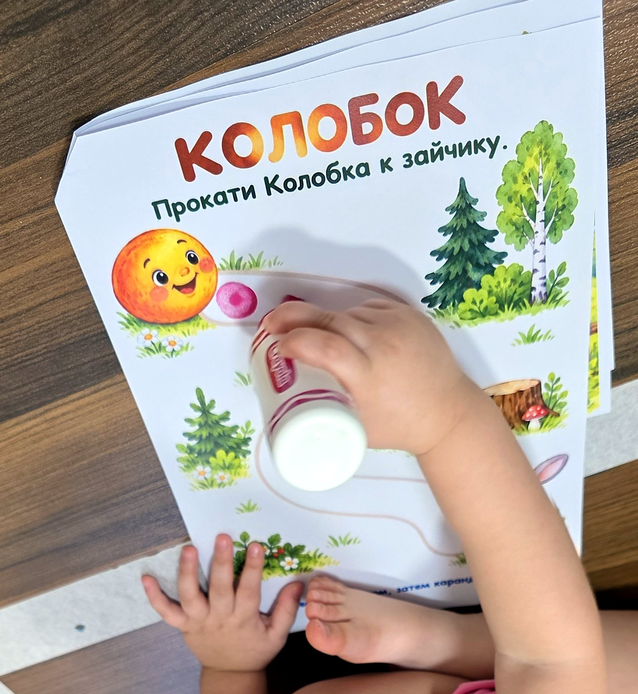 Рука ребёнка с маркером на листе с колобком