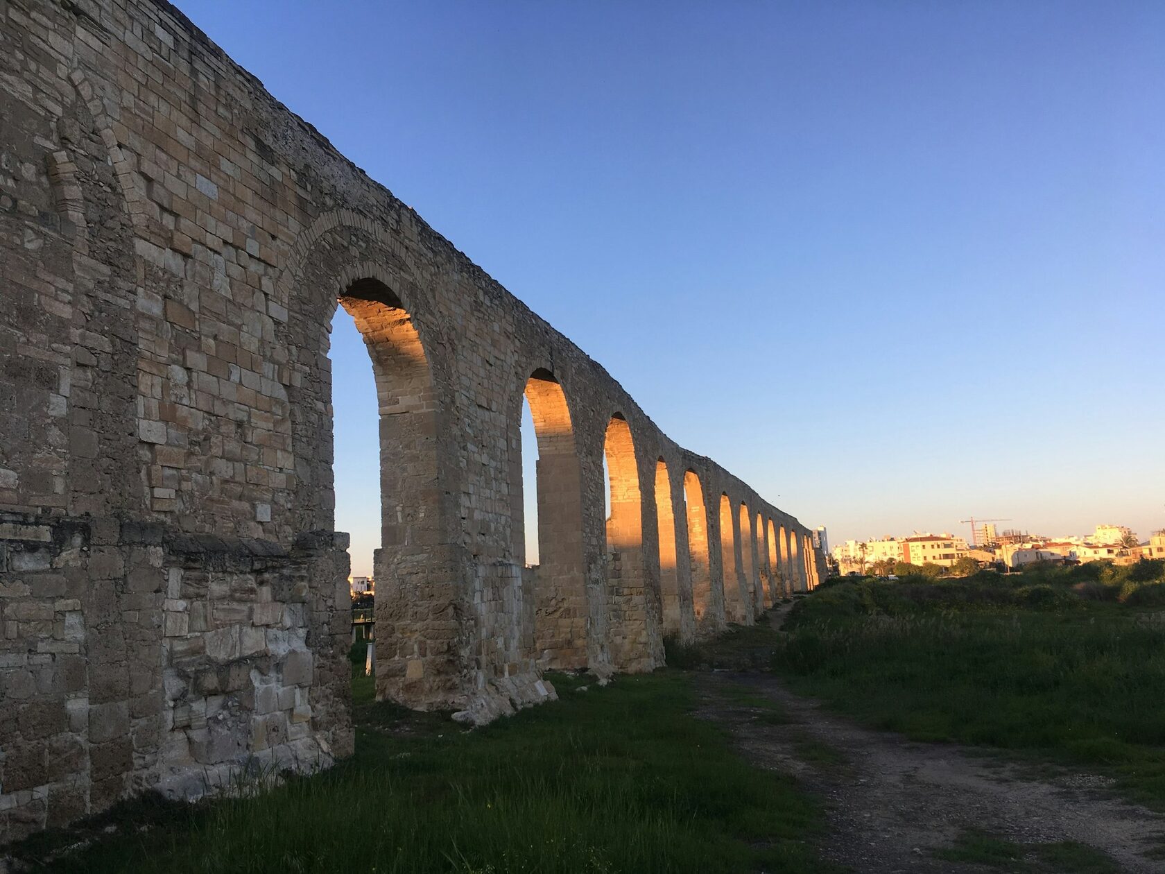 The three-tiered Roman Pont du Gard glowing at golden hour above the green Gardon River