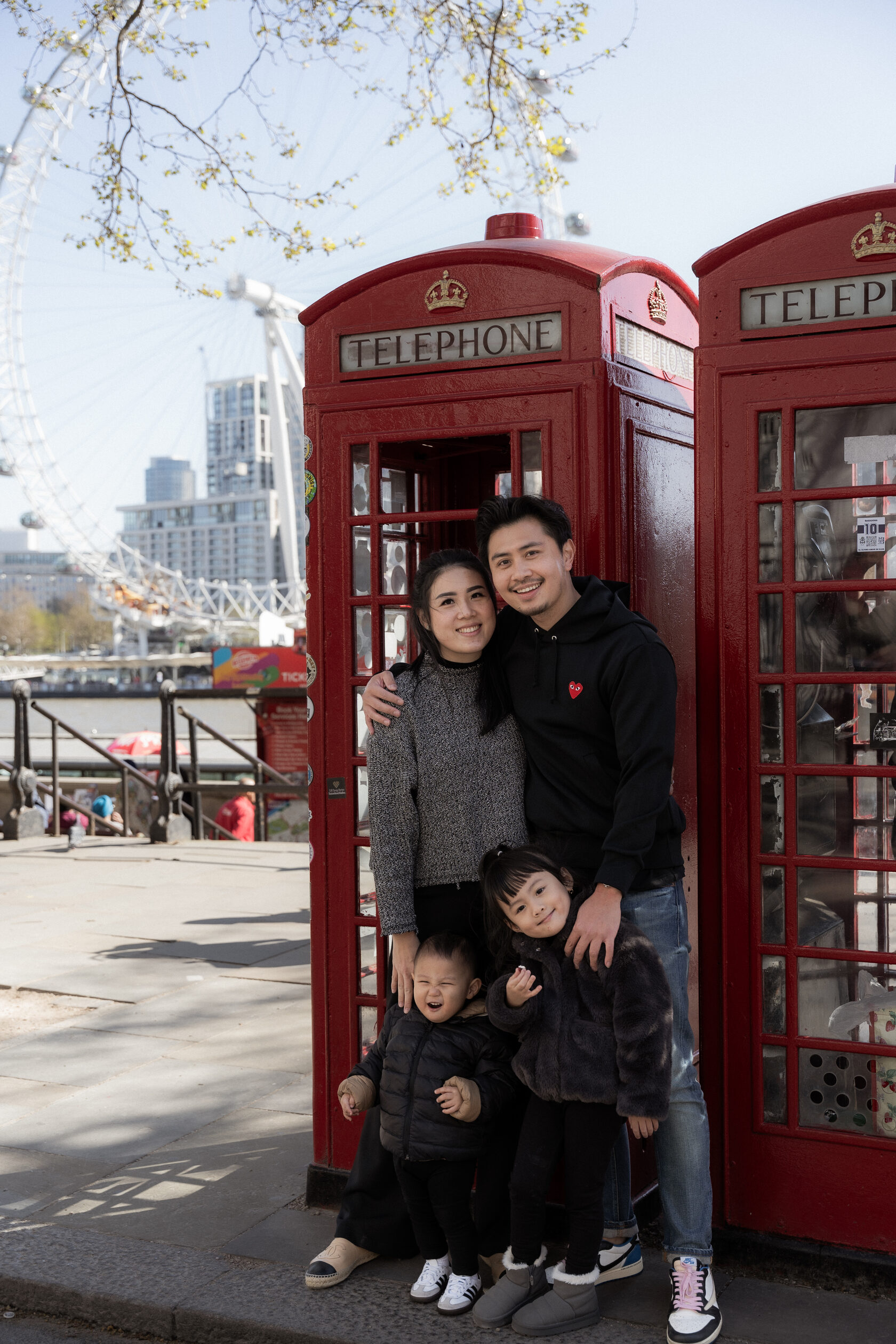 Family together inside a red London telephone box