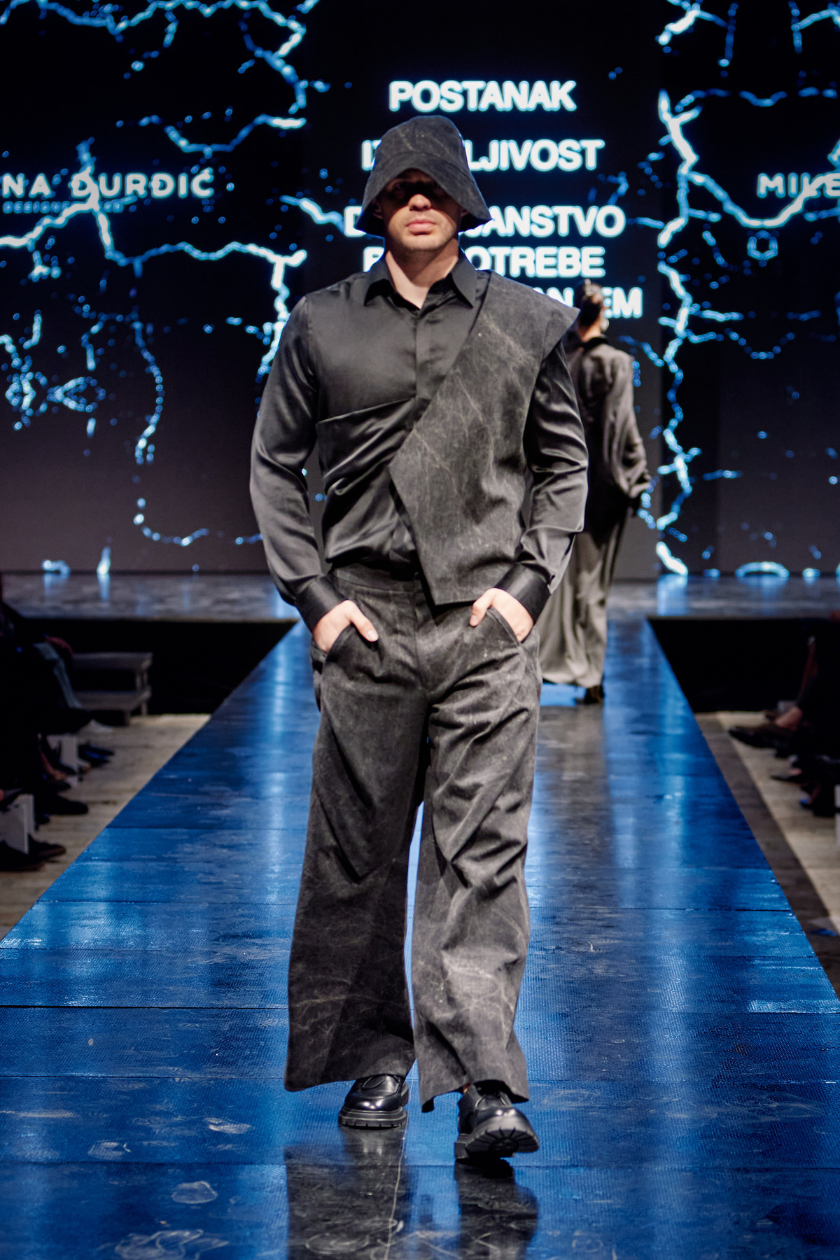 Blue sculptural menswear with a hat