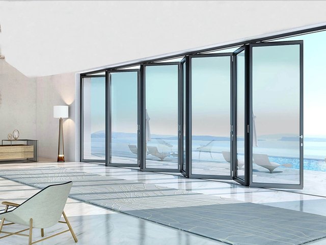PIEGA aluminum folding glass doors opening a room to a pool terrace
