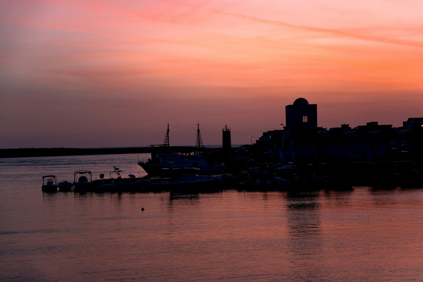 Fishing boats in a Mediterranean harbor at golden hour
