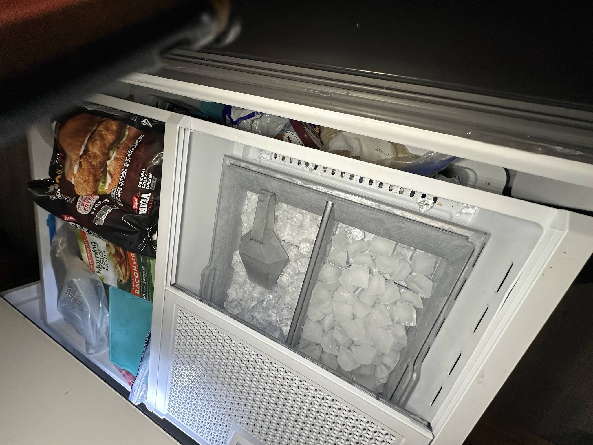 Open freezer drawer with ice bins in a customer’s home during an AVM Services freezer repair visit