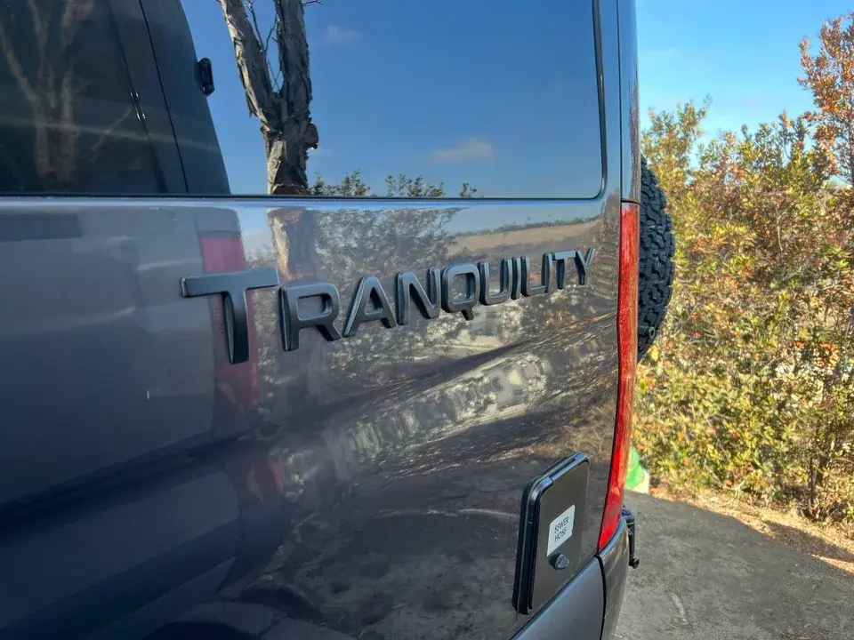 Rear of a dark Thor Tranquility camper van with the Tranquility badge visible.
