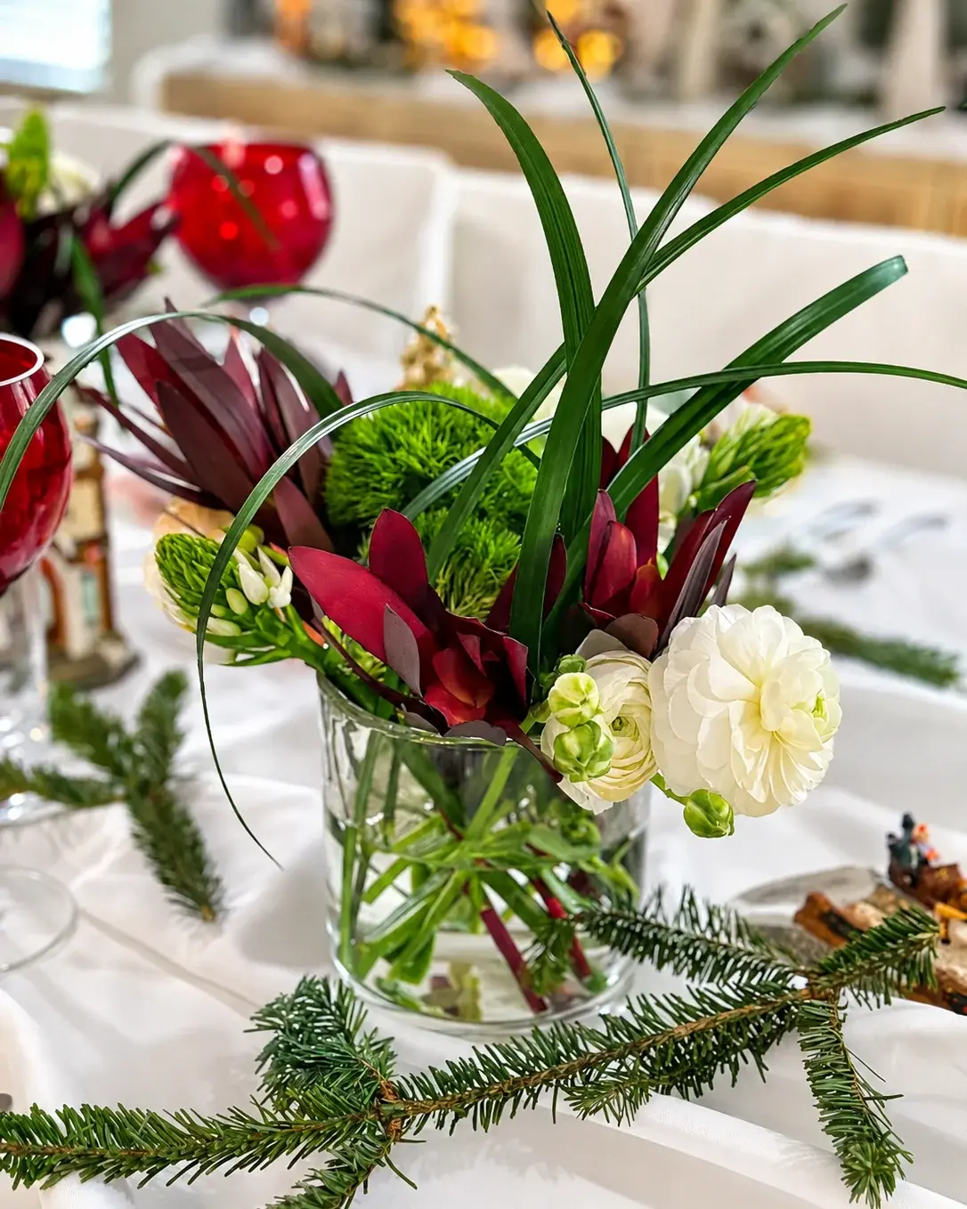 Flowers and winter greens in the middle of the table — a Christmas dinner at home by Miami private chef Marina Staver