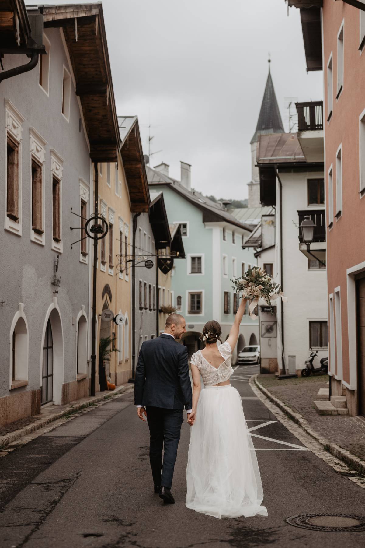 Newlyweds walking hand in hand through Marktschellenberg