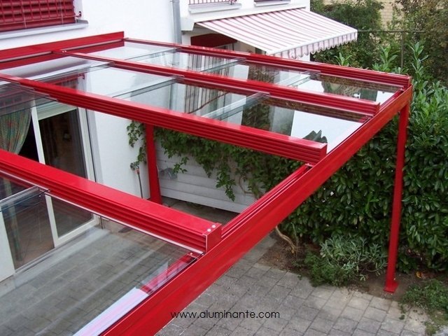 SKYTECH glass roof with a red aluminum frame over a house terrace