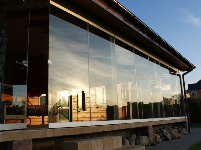 ORIZZONTE THERMO frameless sliding glazing on a timber house terrace