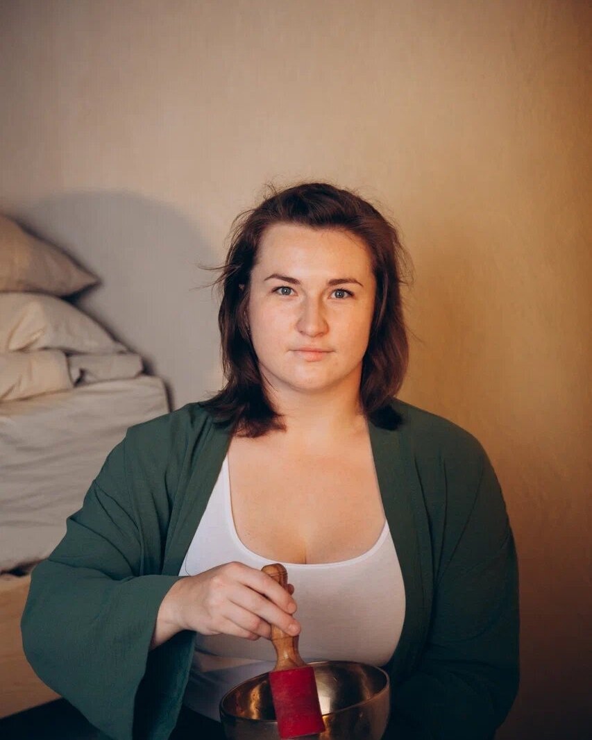 A woman holding a singing bowl