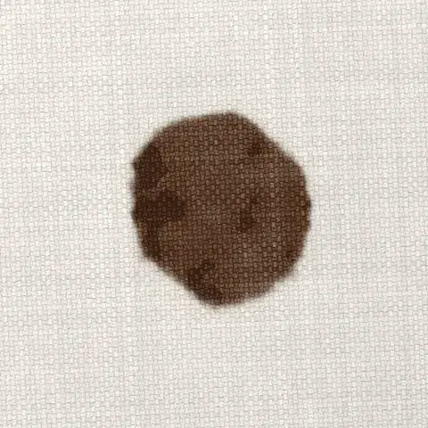 Symbolbild: frischer Schokoladenfleck auf hellem Sofastoff in Nahaufnahme Symbolbild: frischer Schokoladenfleck auf hellem Sofastoff in Nahaufnahme. Ein typischer Kinderfleck, den Shikardos Reinigung in Frankfurt oft sieht.