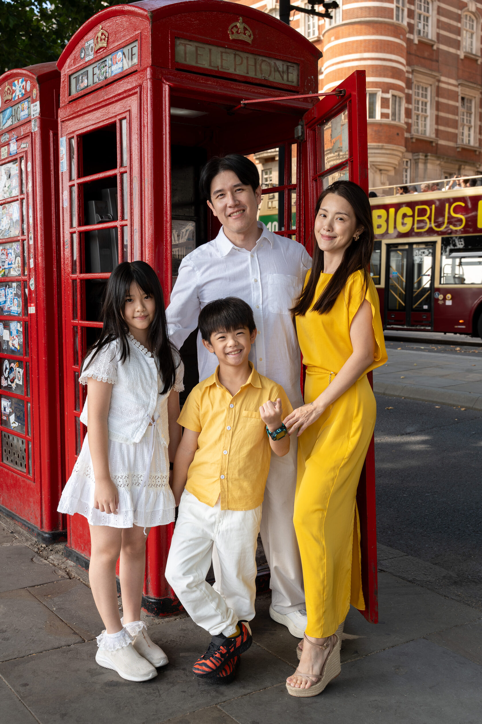 Family of four beside a red telephone box in London
