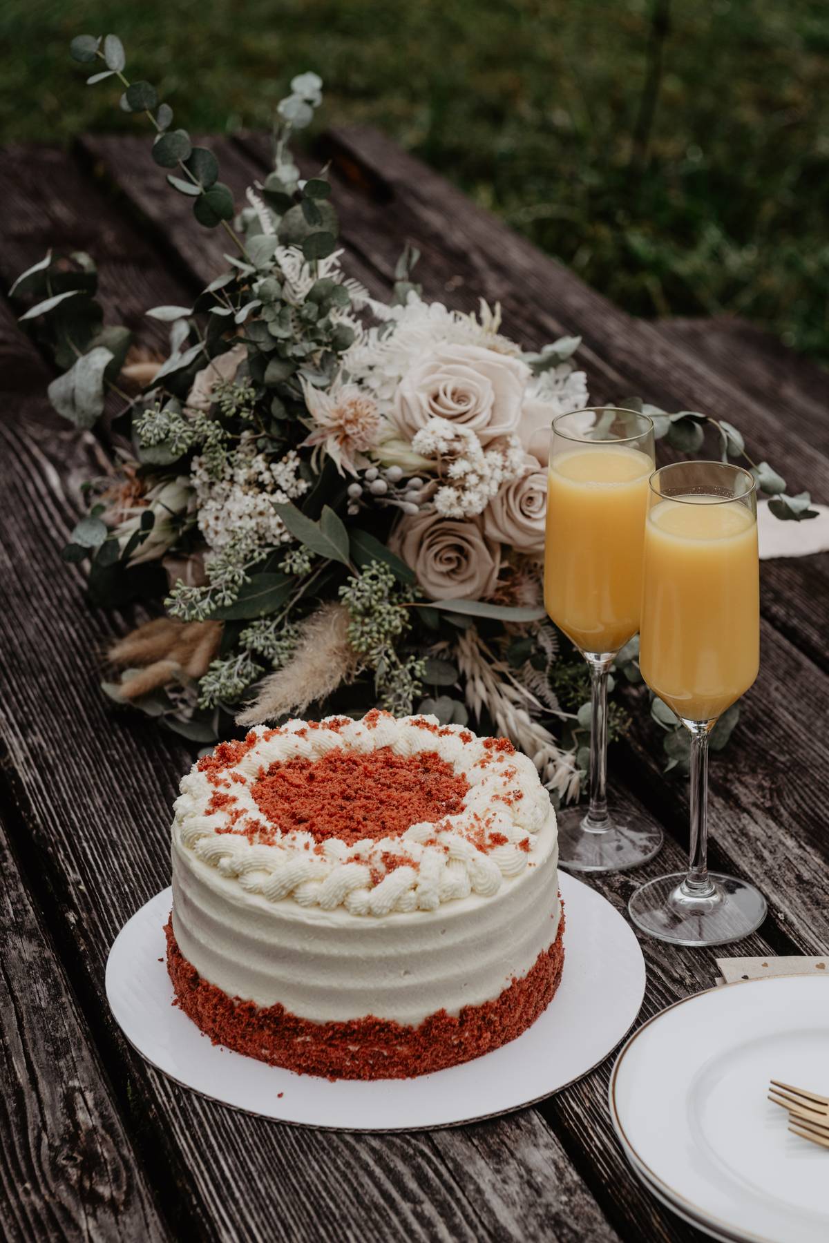 Red Velvet wedding cake beside the bridal bouquet outdoors