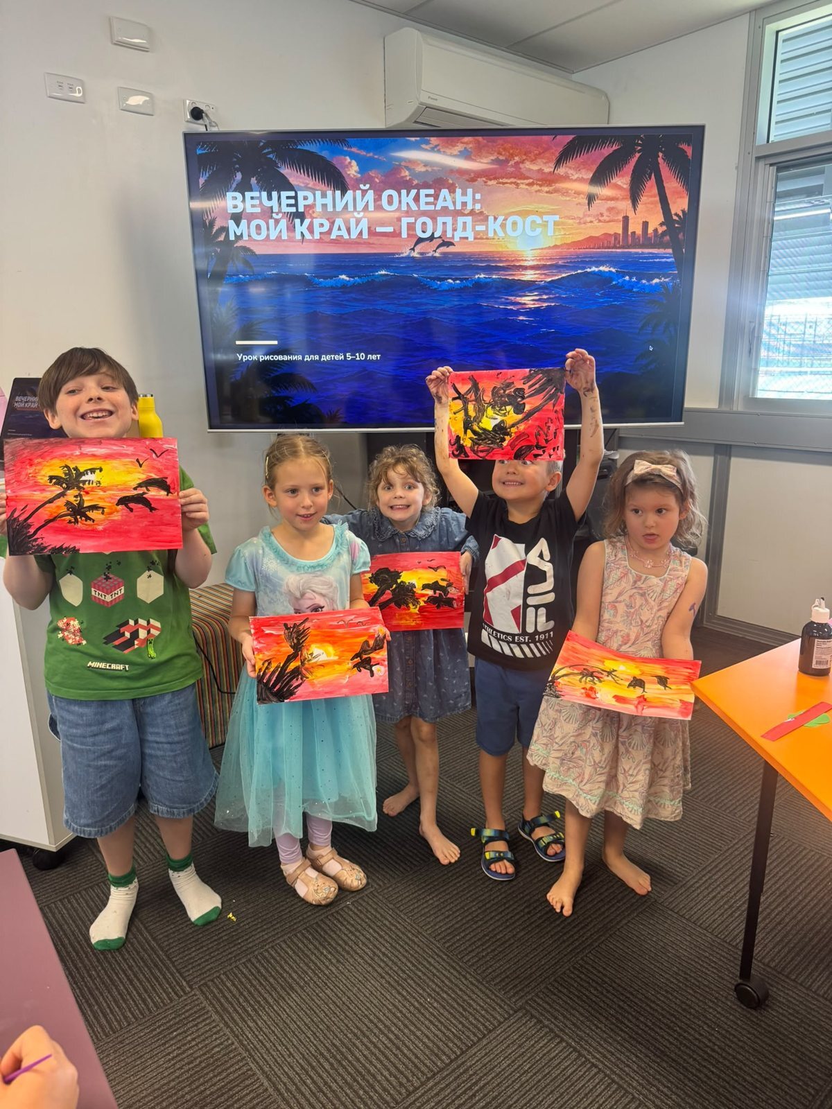 Children showing their paintings of the Gold Coast ocean