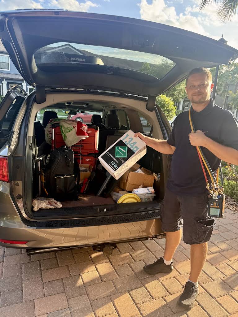 Alex, AVM Services appliance repair technician, at his service van with tools and parts in Wesley Chapel, FL