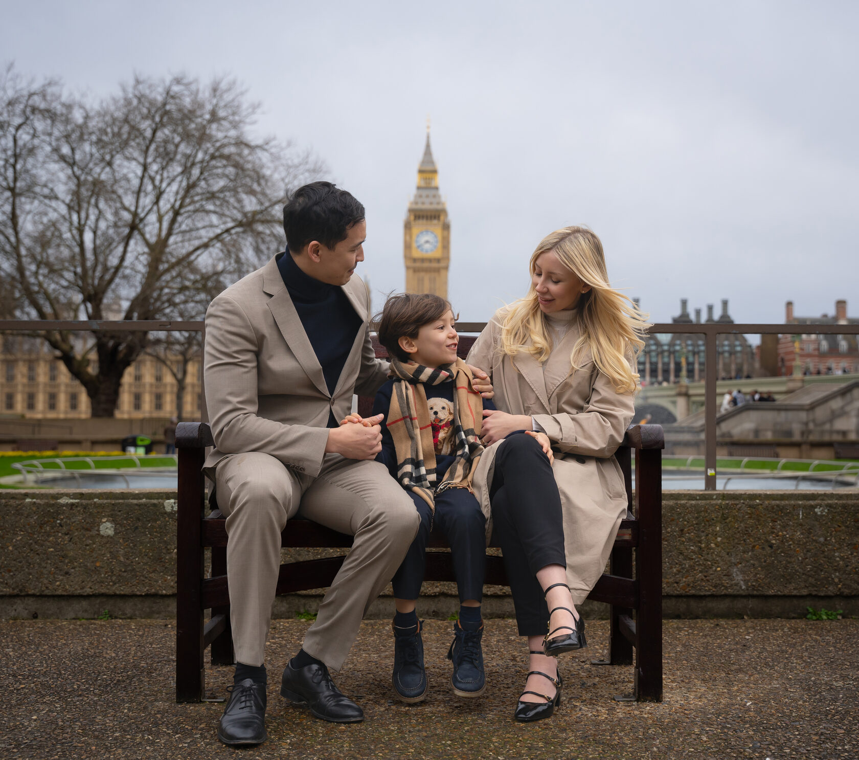 Parents and child sitting on a park bench