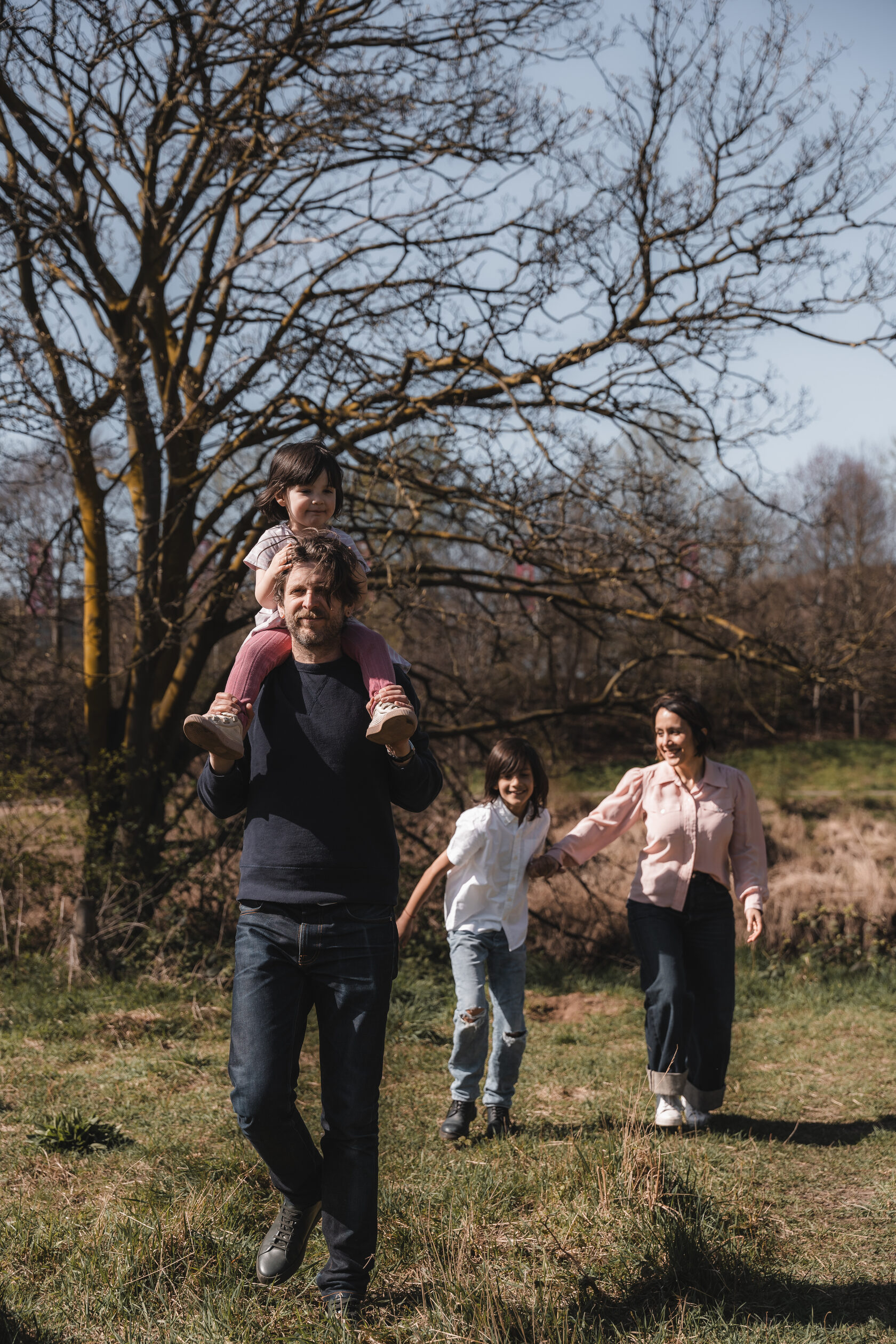 Family enjoying a walk through a tree-lined park