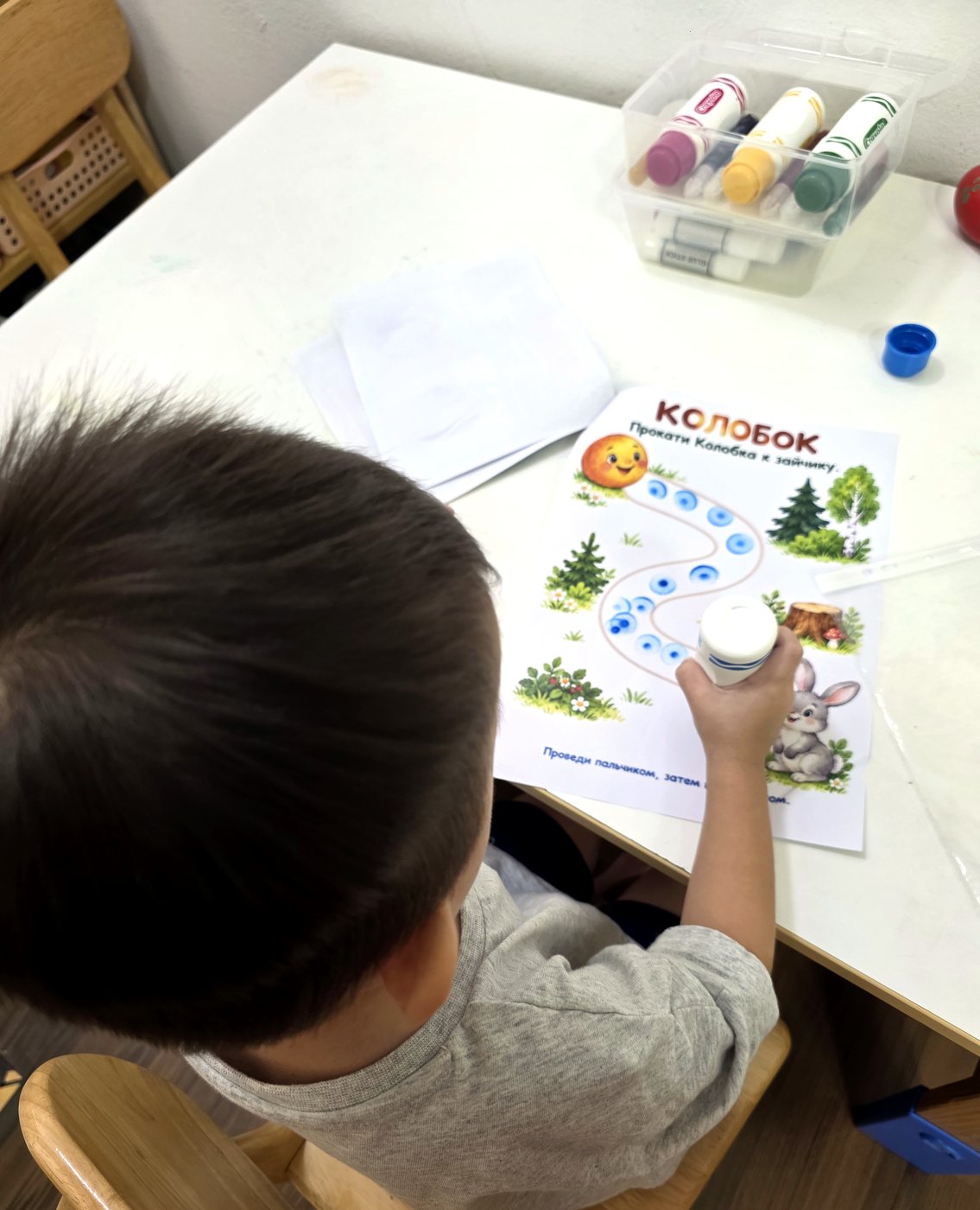 Ребёнок раскрашивает задание «Прокати Колобка к зайчику»