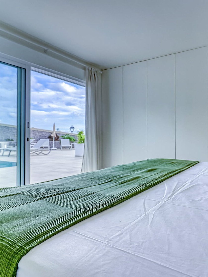 A bedroom with glass doors to the pool