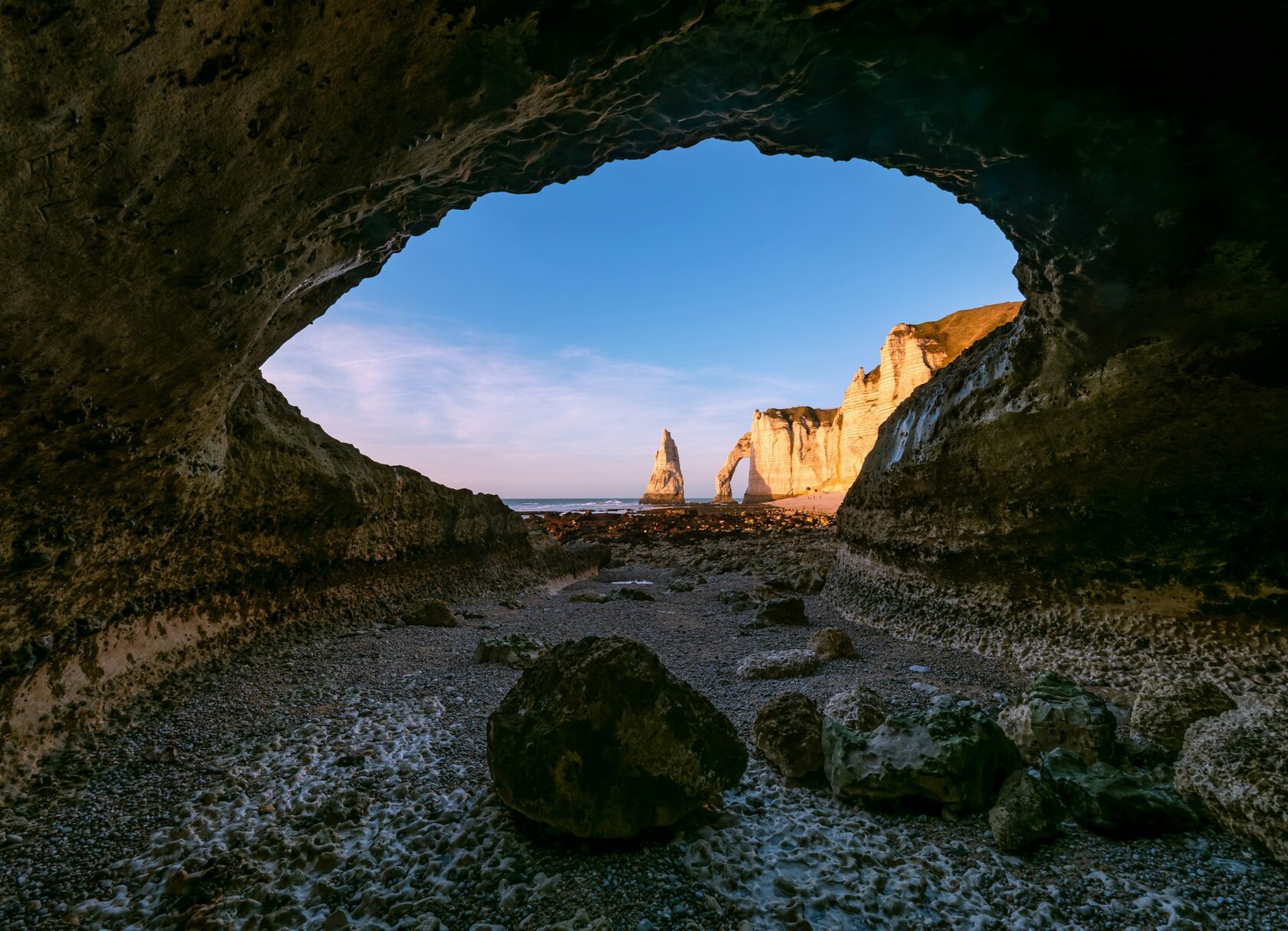 The white chalk cliffs and natural arch of Étretat above the sea at sunset