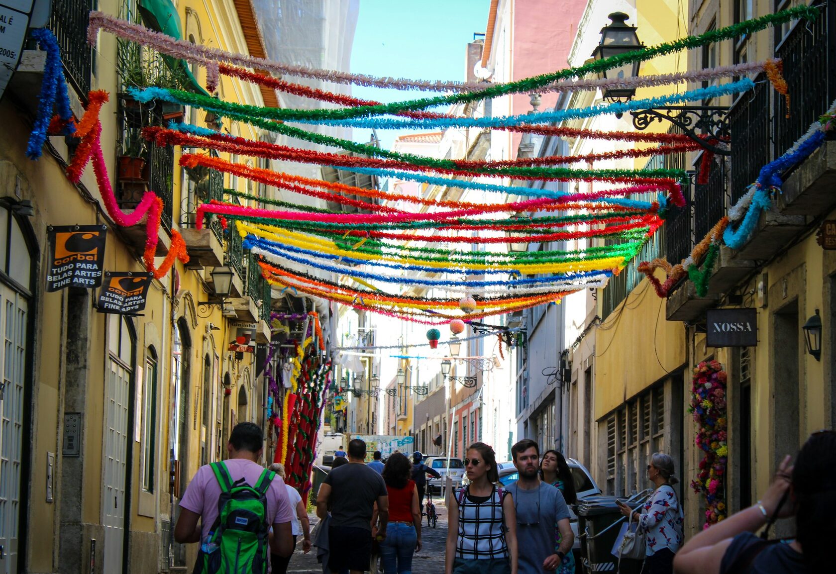 A narrow Lisbon street strung with colorful paper garlands for the June festivals