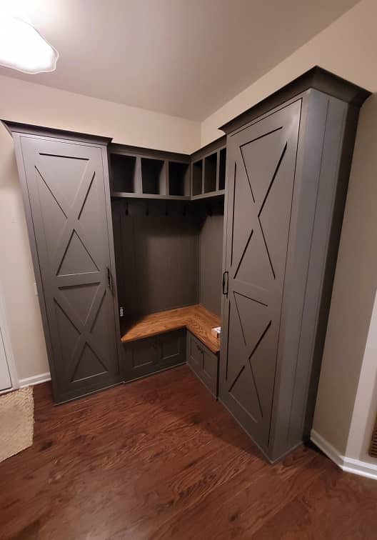 Diagonal view of farm house style mudroom cabinets with built-in bench in dark grey color