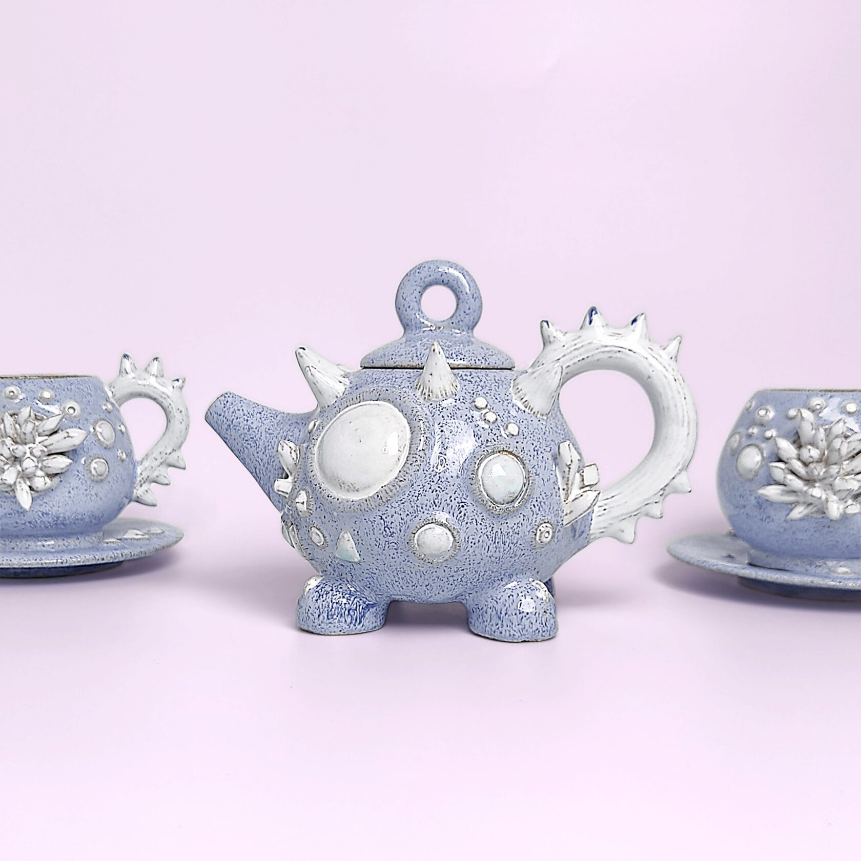 Unique handmade fairy-tale ceramic tea set shaped like a whimsical crystal-covered little monster, featuring a sculptural teapot and two matching cups with saucers