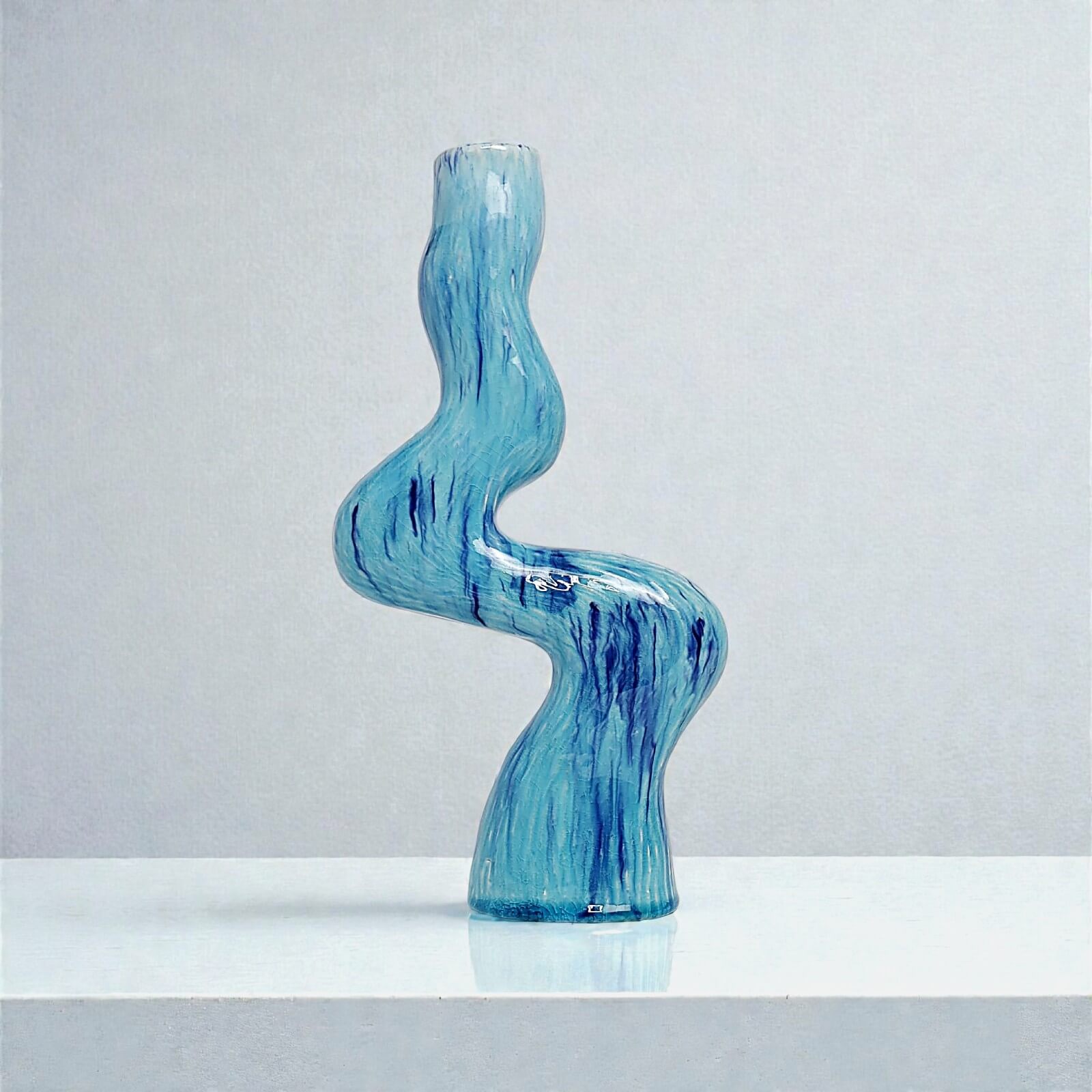 Handmade ceramic candle holder for one candle, wavy shape, glossy glaze, blue with dark blue streaks, artisanal decor item