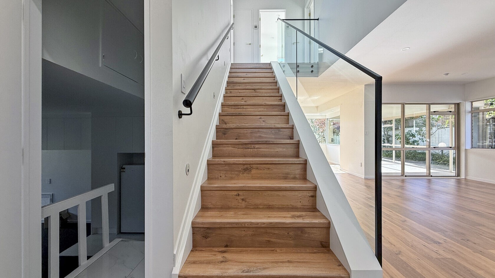 Timber staircase and open living area after the St Heliers renovation