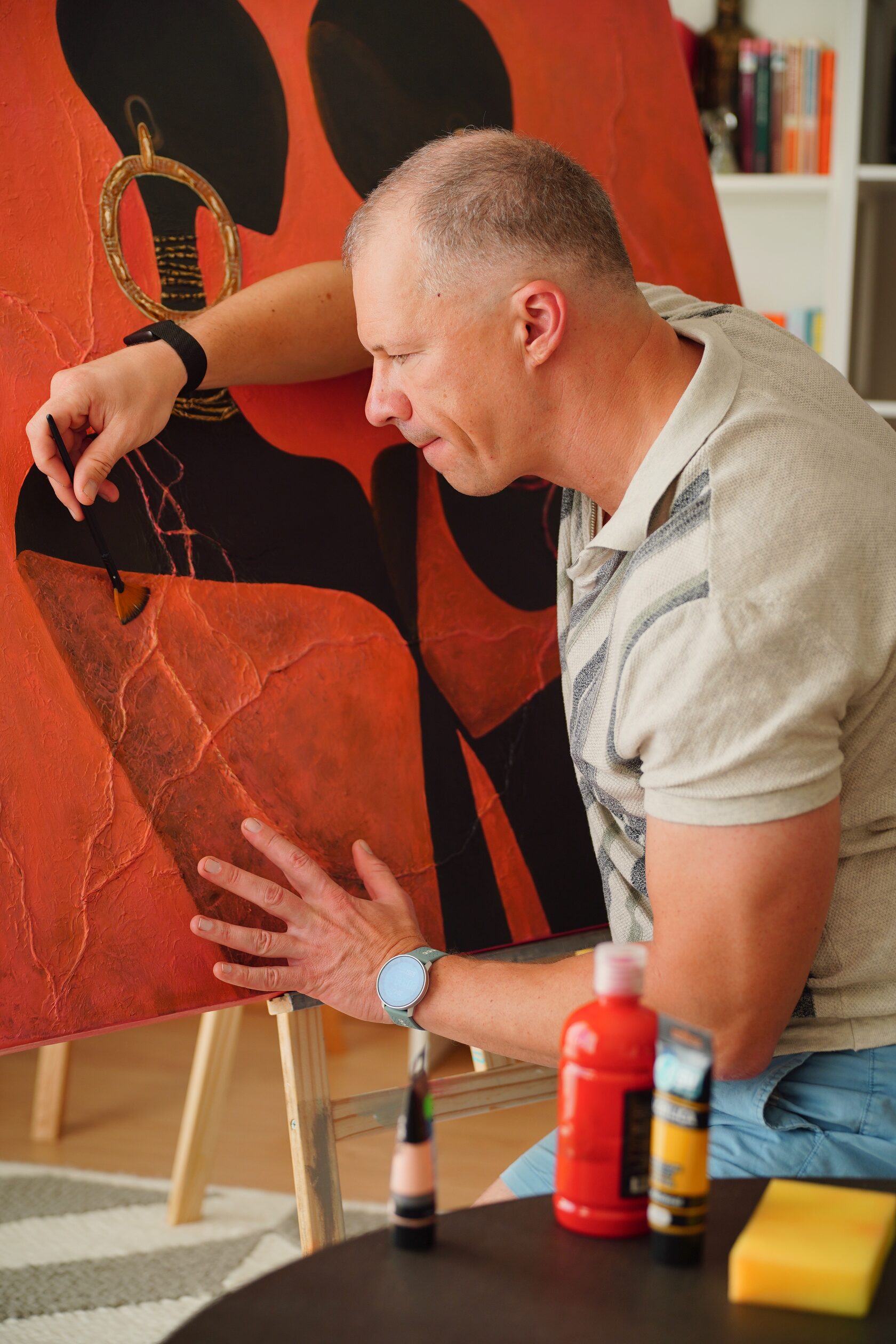 The artist at work in the studio, holding a palette and brush