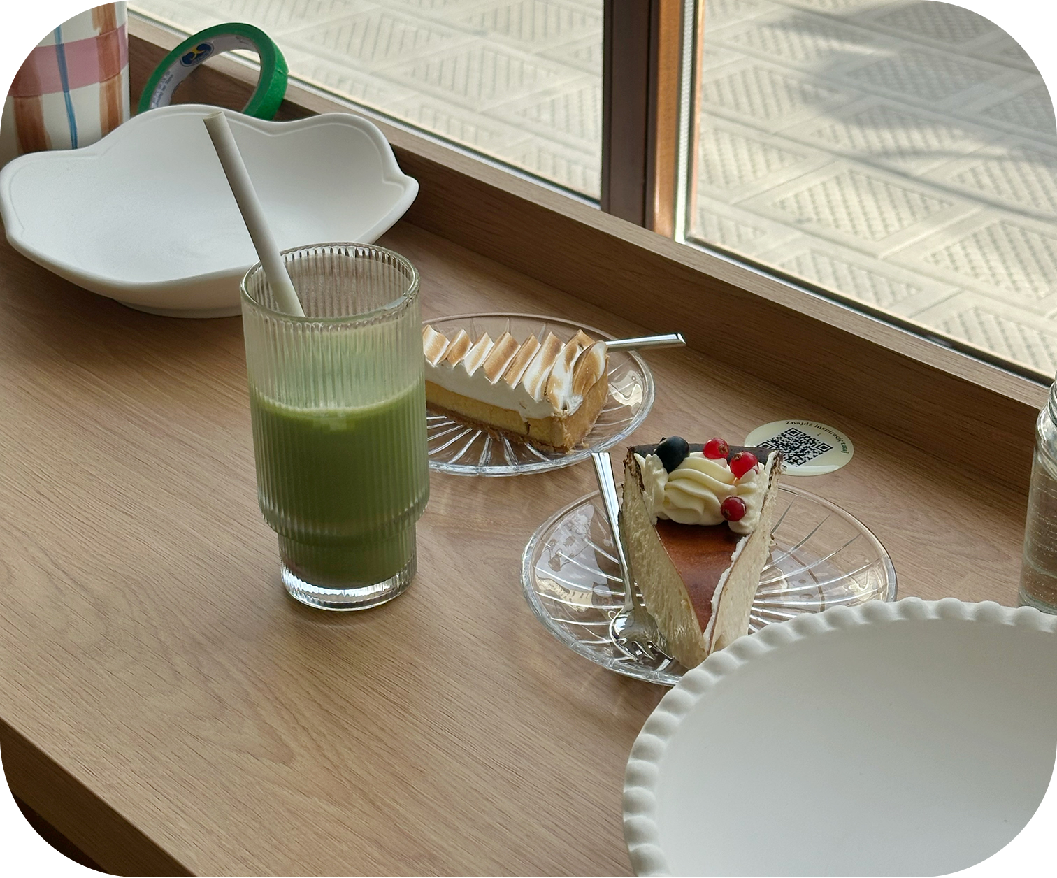 Matcha latte and cake on a table by the window in a ceramics café in Poznań